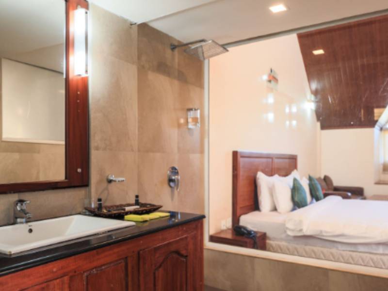 Premium luxury room interior with elegant décor and nature-view balcony at Shola Crown.